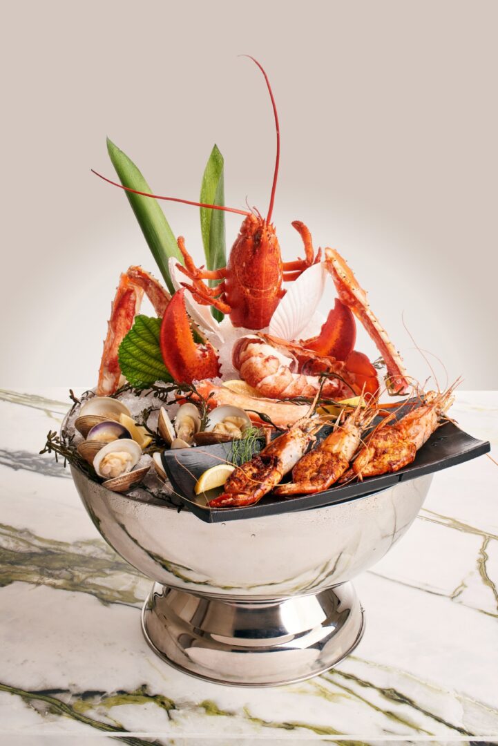 A bowl of fresh seafood on a marble table at a hotel.