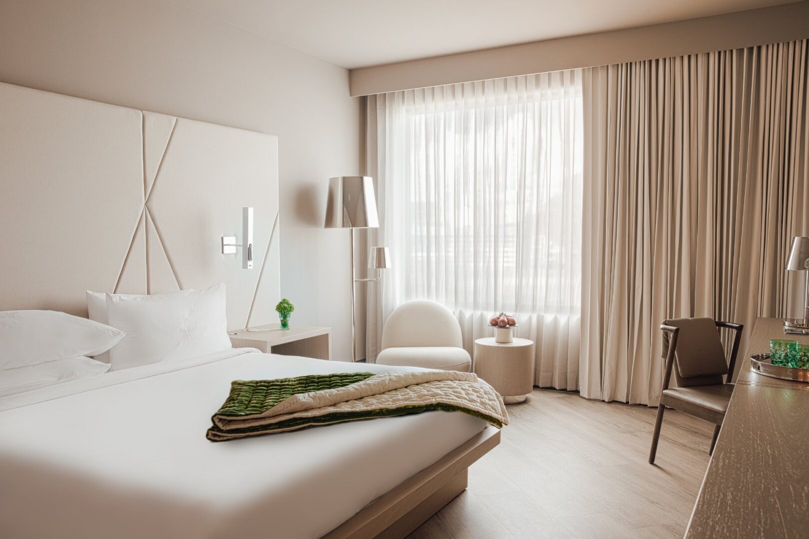 A bedroom with a bed, chair and window.