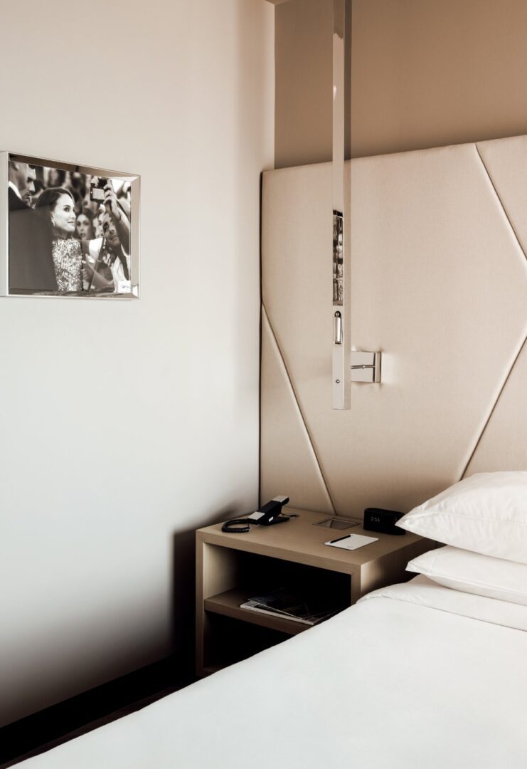 A bedroom with a bed, nightstand and picture on the wall.