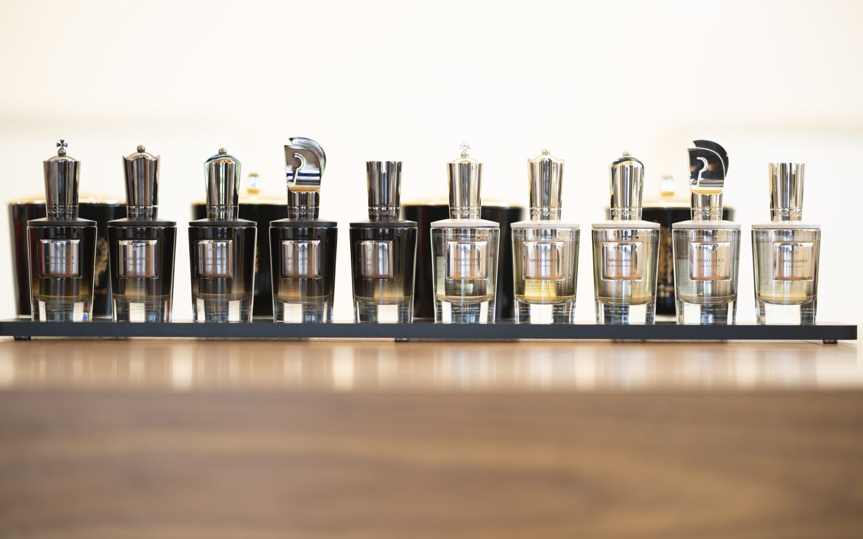 A row of bottles on top of a wooden table.