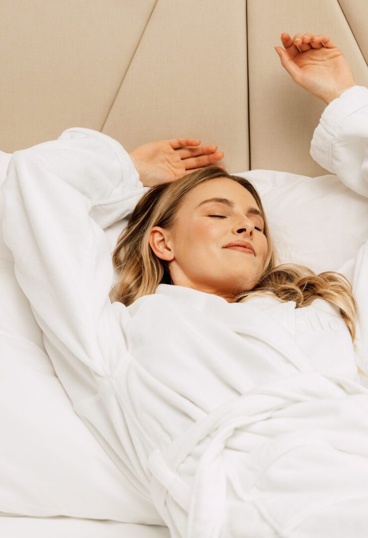 A woman laying in bed with her eyes closed.