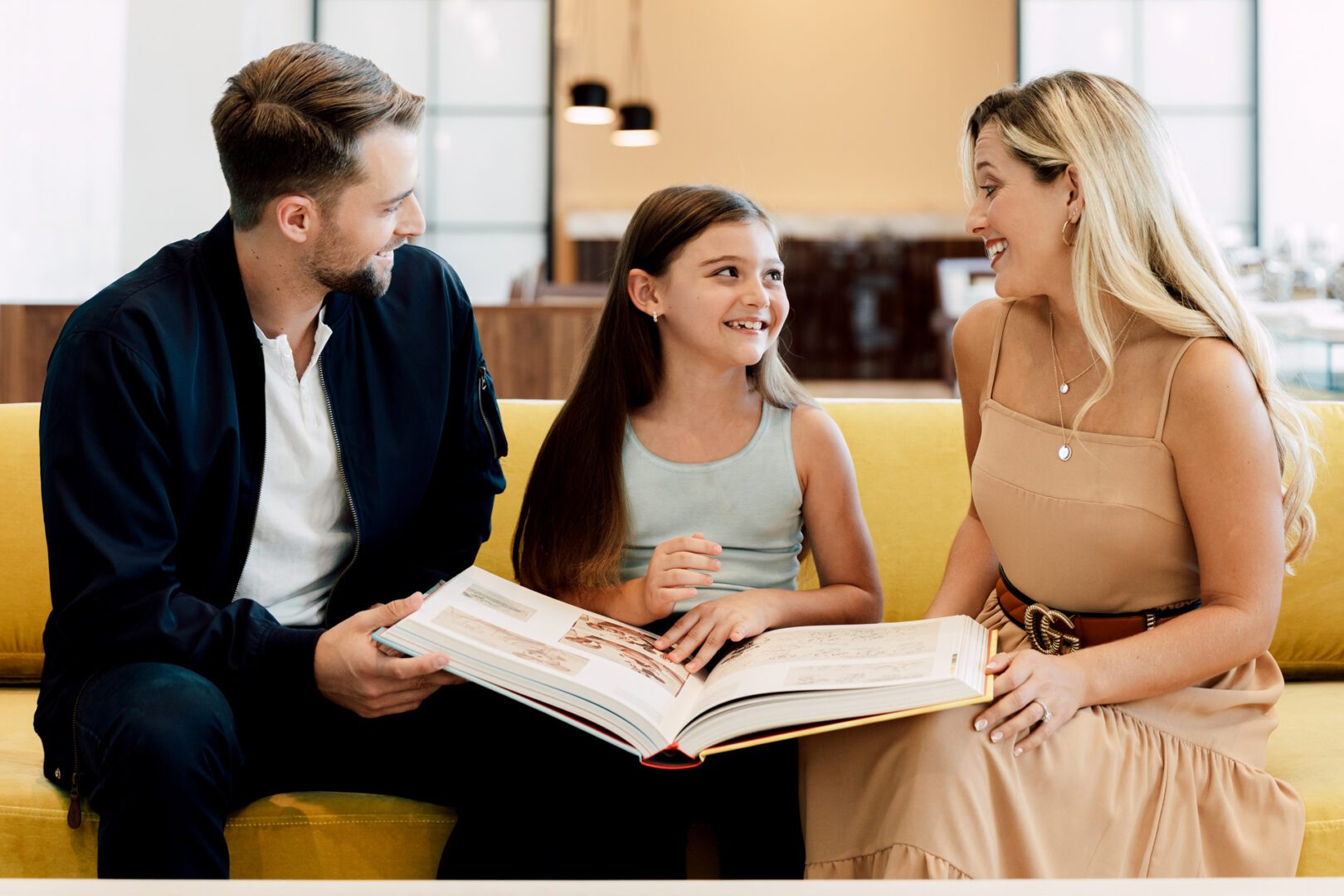 A woman and two men are holding open books