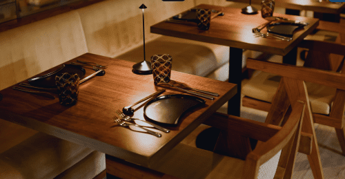 A table and chairs with plates and silverware from ette hotel's restaurant and area.