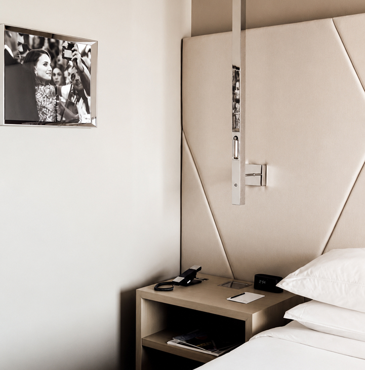 Upholstered headboard, nightstand and framed artwork in the Elegant King room at ette hotel